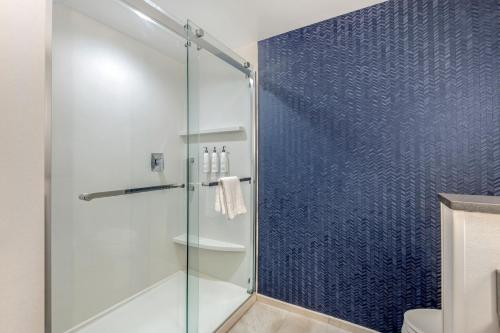uma casa de banho com uma cabina de duche em vidro com paredes azuis em Fairfield by Marriott Inn & Suites North Conway em North Conway