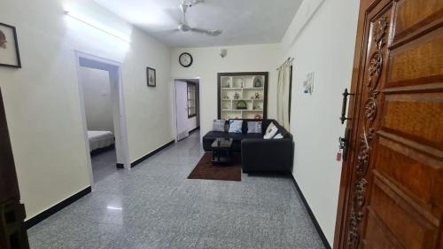 a living room with a black couch in a room at Happy Home in Coimbatore