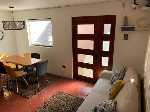 ein Wohnzimmer mit einem Sofa, einem Tisch und einer Tür in der Unterkunft HOsTAL PALMED in Concepción
