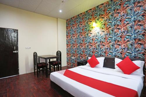 a bedroom with a bed with a colorful wall at Hotel O Platinum Inn in Faridabad