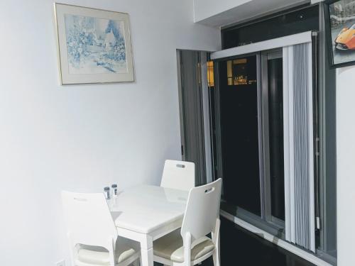 uma mesa branca e cadeiras num quarto com uma janela em ICE Condominiums em Toronto
