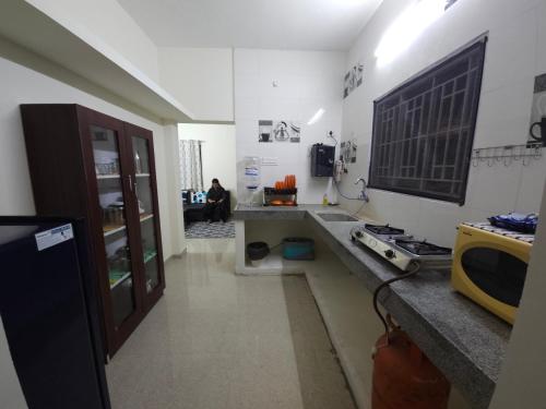 a kitchen with a counter and a tv on the wall at Happy Home in Coimbatore