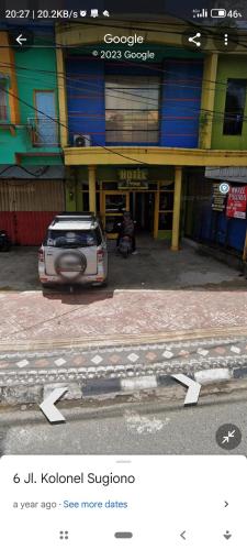 a white car parked in front of a building at Hotel prima in Benuaanyar