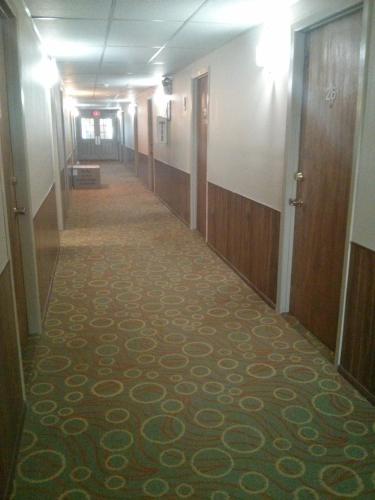 a hallway of an office building with a carpet at Port Motel in Port Colborne