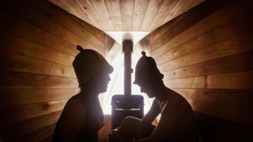 two people standing in a dark room with a lamp at LAMP Nojiriko The Sauna by the Lake in Shinano