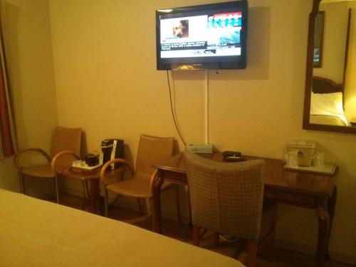 a room with a table and a television on the wall at Port Motel in Port Colborne