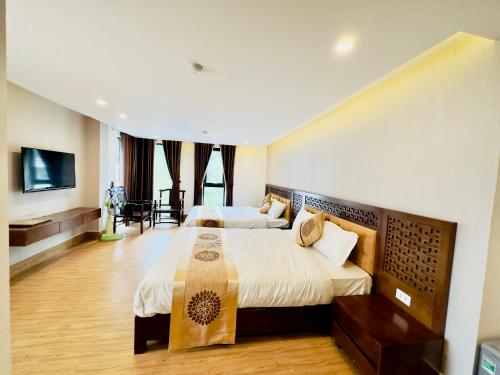a hotel room with two beds and a television at Romance hotel in Cat Ba