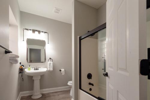 a white bathroom with a sink and a mirror at Main Street Balcony Apartment For up to 8 guests! in St. Charles