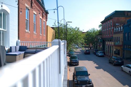 a view of a city street with cars parked on a balcony at Main Street Balcony Apartment For up to 8 guests! in St. Charles