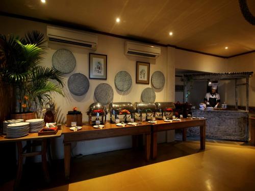 een eetkamer met een tafel met borden eten bij AlamKulkul Boutique Resort in Kuta