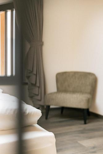 a bedroom with a chair and a window at Hillepranter in Marlengo