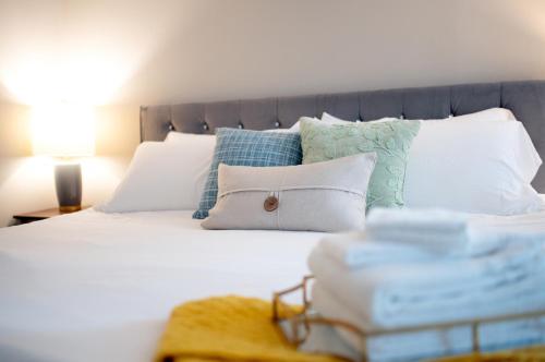 a bed with white and blue pillows and a table with a lamp at Private Basement Retreat in St. Charles