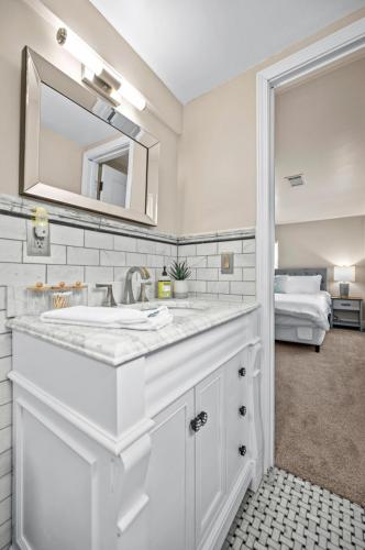 a white bathroom with a sink and a mirror at Private Basement Retreat in St. Charles