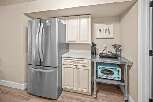 a kitchen with a refrigerator and a table with a microwave at Private Basement Retreat in St. Charles