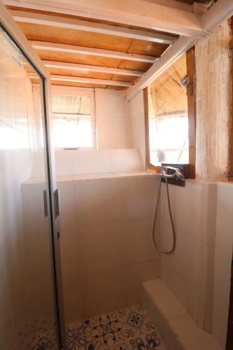 a bathroom with a shower and a window at Seabreeze Hostel Bali in Canggu
