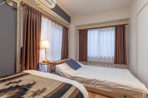 a hotel room with two beds and a window at Tsukimura Building in Tokyo