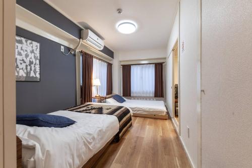 a hotel room with two beds and a window at Tsukimura Building in Tokyo