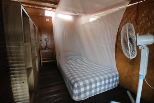 a small bed in a room with a ceiling at Seabreeze Hostel Bali in Canggu
