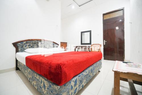 1 dormitorio con 1 cama grande con manta roja en Hotel Borobudur Kemayoran Syariah Mitra RedDoorz, en Yakarta