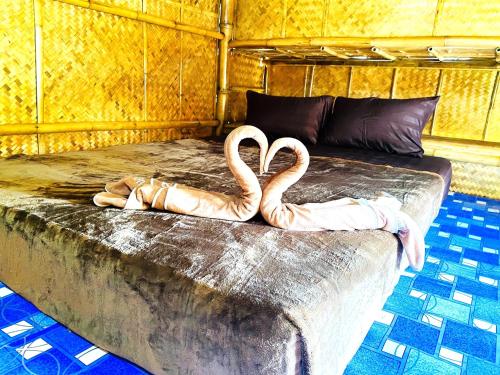 two flamingos sitting on top of a bed at Asama Bungalow in Ko Lanta