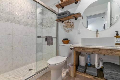 a bathroom with a shower and a toilet and a sink at Cozy Cottage • King Bed • Grove • Kayaks • Boat Parking in Grove