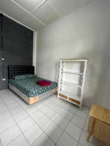 um quarto com uma cama e uma prateleira em Sejahtera Homestay em Cangkringan