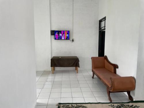 uma sala de espera com uma cadeira e uma mesa em Sejahtera Homestay em Cangkringan