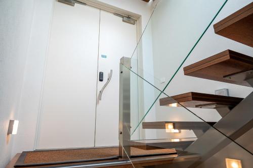 a glass staircase in a house with wooden steps at Taupo Penthouse in Taupo