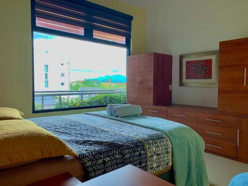 a bedroom with a bed and a large window at CASA GUME - Departamentos con 2 habitaciones para 4 personas in Oaxaca City