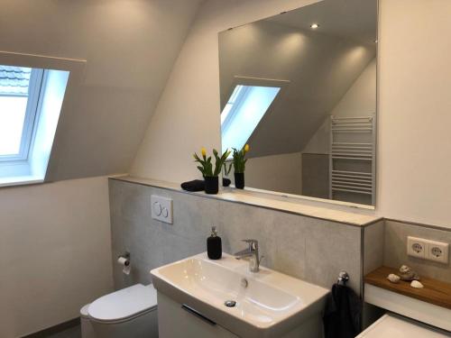 Un baño con lavabo, inodoro y espejo. en Ferienwohnung Plön am See, en Plön