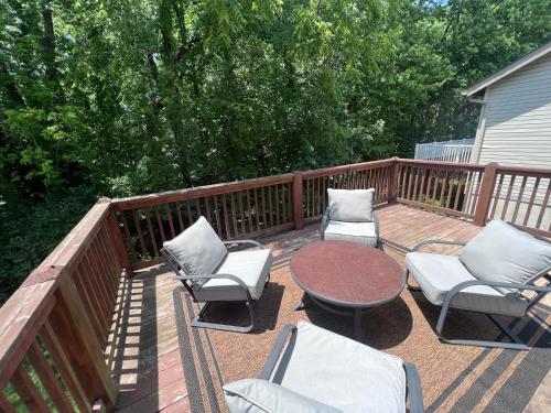 a deck with chairs and a table and a table and chairs at Springhurst Serenity Fresh 4BR Getaway in O'Fallon