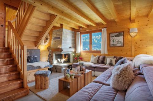 a living room with a couch and a fireplace at Chalet Batieu - OVO Network in La Clusaz