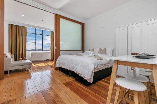 1 dormitorio con 1 cama, mesa y sillas en Heritage beauty, en Auckland