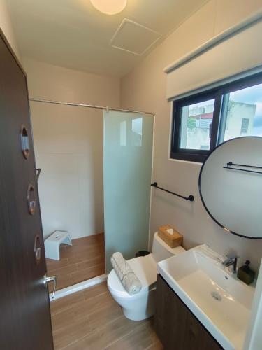 a bathroom with a toilet and a sink and a mirror at 日日和 in Tainan
