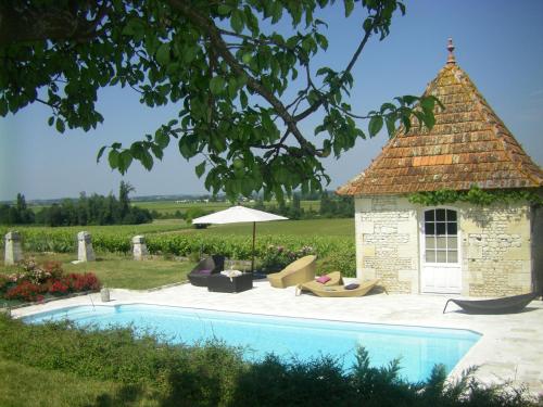 a swimming pool with a gazebo next to a house at Chambre d'Hôtes Clos des Pierres Blanches in Brie-sous-Archiac