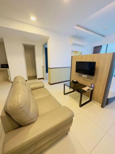a living room with a couch and a television at D'Wharf Hotel & Serviced Residence in Port Dickson
