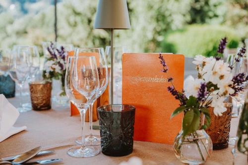 a table with wine glasses and flowers on it at Hotel Brücklwirt in Niklasdorf