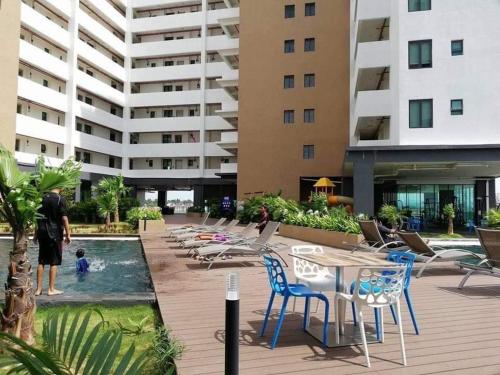 um homem parado numa piscina ao lado de um edifício em D'Wharf Hotel & Serviced Residence em Porto Dickson