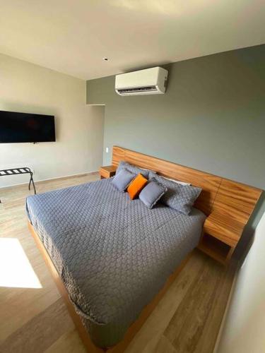 a bedroom with a bed with pillows on it at Ocean view apartment close to de beach and 5th Av in Playa del Carmen
