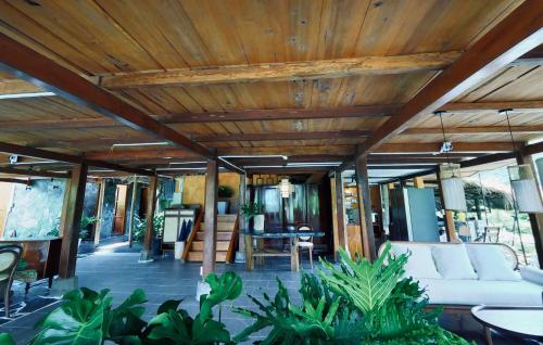 a living room with a white couch and a wooden ceiling at Thavill Retreat HaGiang in Ha Giang