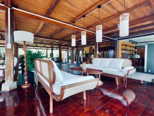a living room with white furniture and wooden ceilings at Thavill Retreat HaGiang in Ha Giang