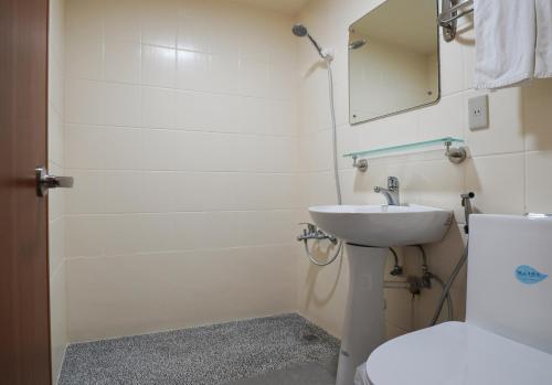 a bathroom with a sink and a toilet and a mirror at Su Ao Hotel in Suao