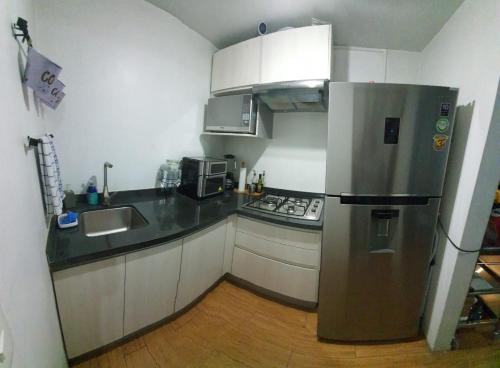 a small kitchen with a stainless steel refrigerator at Aeropuerto CDMX, foro sol, la casa de Leo in Mexico City