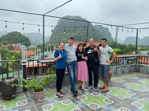 a group of people posing for a picture on a balcony at Hang Múa Green Mountain View House in Ninh Binh