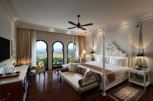 a large bedroom with a bed and a couch at Fairmont Jaipur in Jaipur