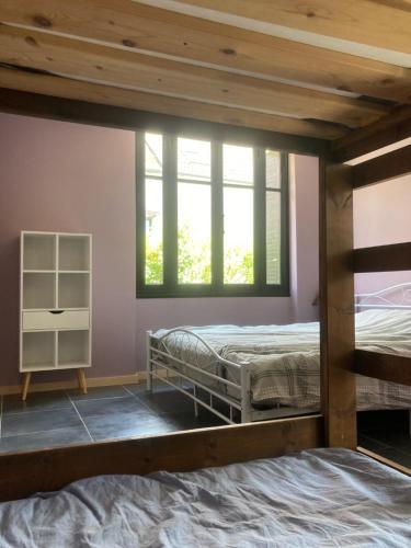 1 dormitorio con 2 literas y ventana en Le petit belge, en Montgivray