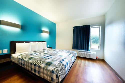- une chambre avec un lit et un mur bleu dans l'établissement Emblaze Hotel, à Three Rivers