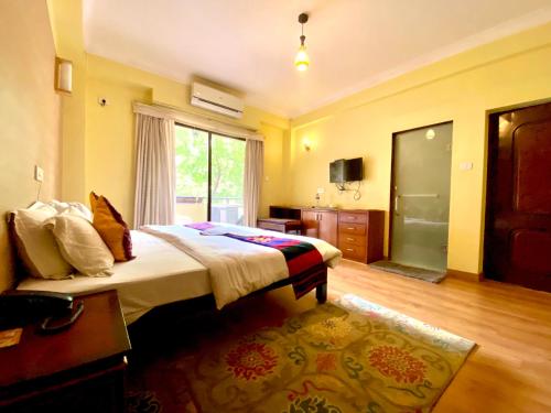 Habitación de hotel con cama y ventana en Hotel Siddhi Manakamana en Katmandú