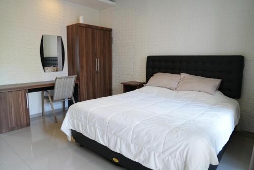 a bedroom with a bed and a desk with a computer at Doris Seminyak Studio in Seminyak