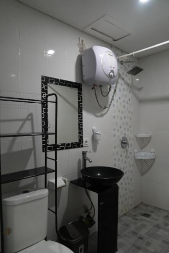 a bathroom with a white toilet and a sink at Doris Seminyak Studio in Seminyak